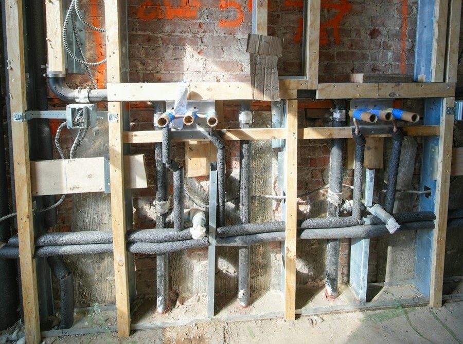 Plumbing and electrical work inside a wall under construction