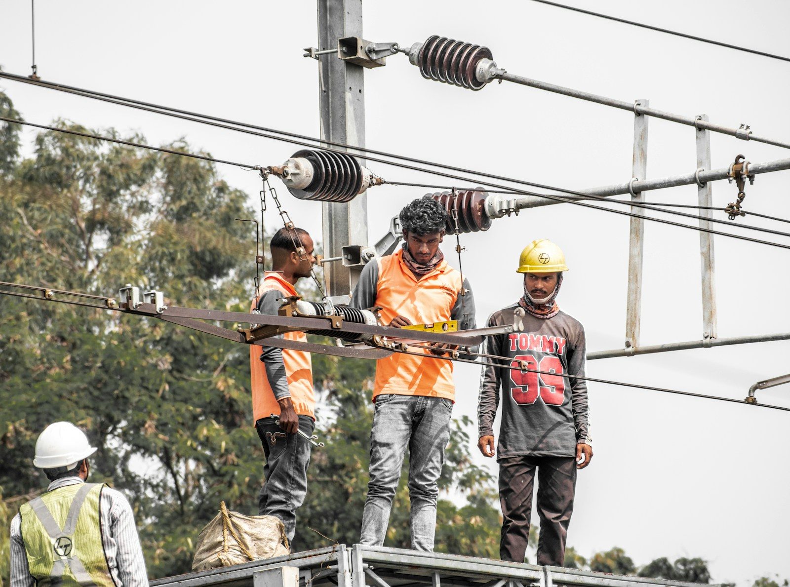 a group of men standing on top of a power line