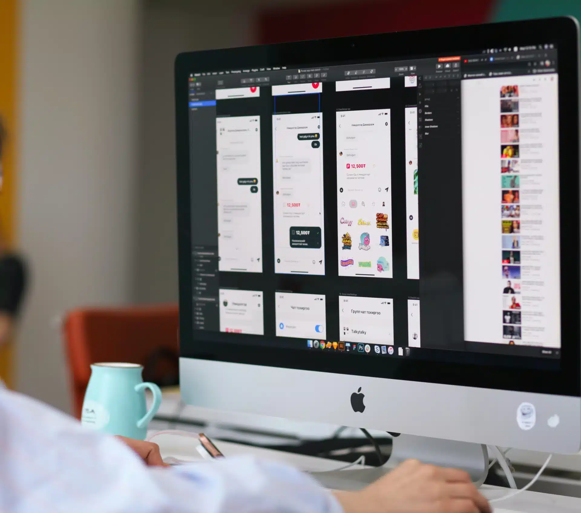 An Apple iMac on a desk displays a design app with multiple mobile UI screens, and a turquoise mug sits nearby.